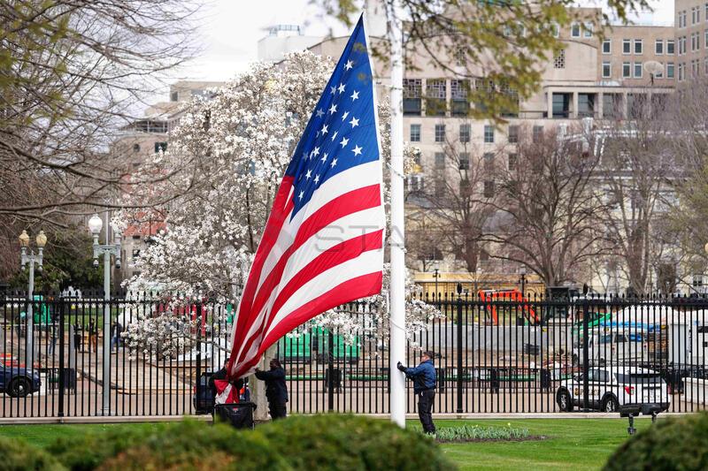 White House grounds staff lowers the American flag